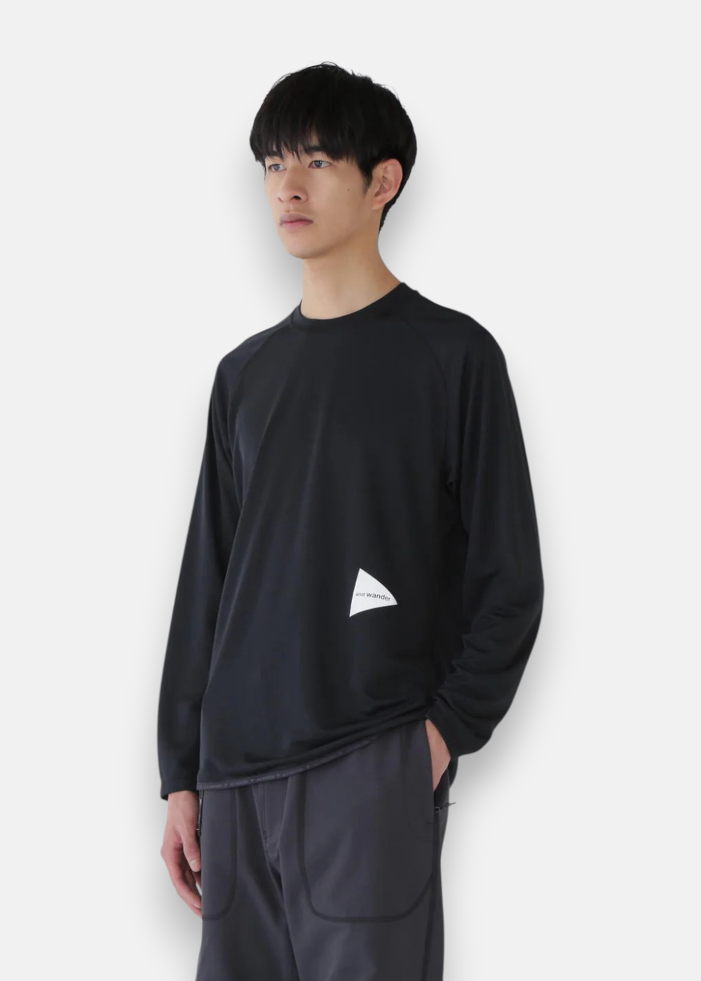 Homme portant le T-shirt Dry Jersey Raglan LS And Wander noir, sous-couche technique pour le running ou la randonnée.