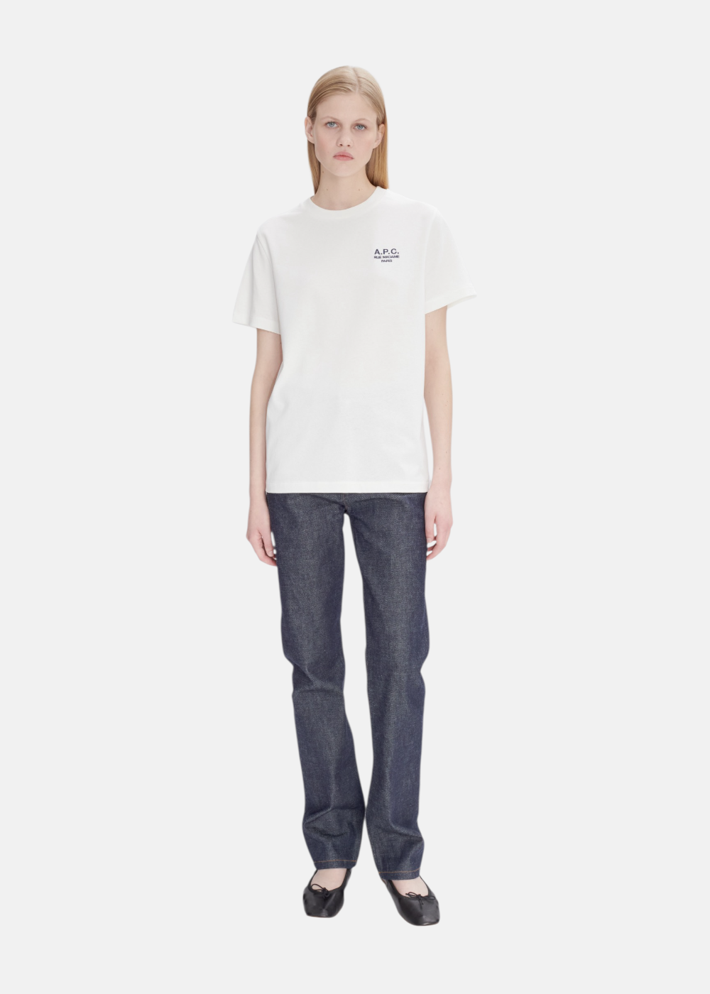 Silhouette complète avec t-shirt blanc A.P.C., jean brut bleu et chaussures de ville minimalistes.