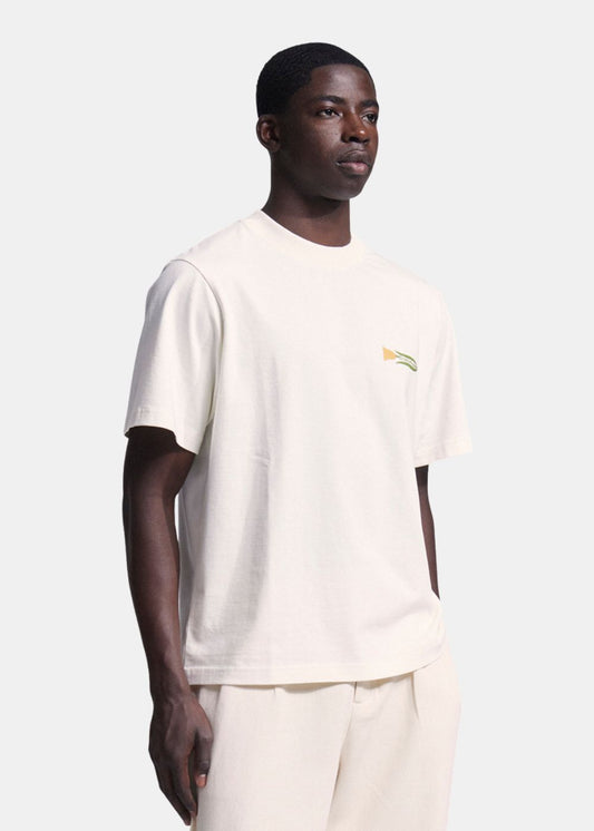 Vue de face en 3/4 du mannequin portant le t-shirt blanc et un pantalon blanc, coupe décontractée.