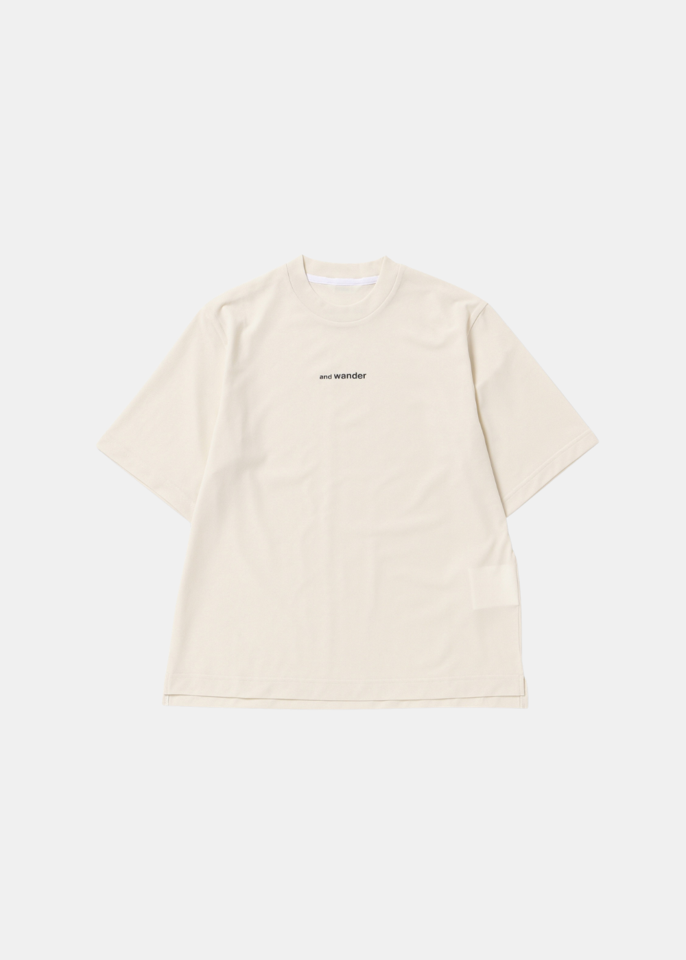T-shirt techwear blanc cassé And Wander Dry Mesh avec petit logo noir au centre du torse, de face.