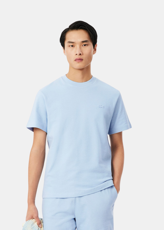 Portrait d'un homme portant le t-shirt bleu ciel Lacoste en crêpe de coton, vue de face