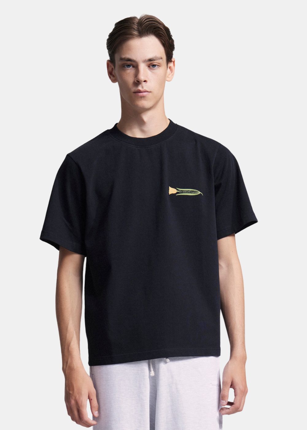 Homme portant le t-shirt noir Bram's Fruit, logo fleur horizontal avec lettrage blanc au niveau du cœur.