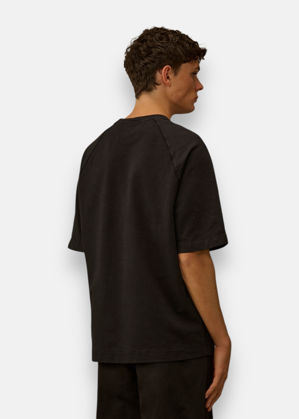 Vue de dos du t-shirt noir C.P. Company porté, montrant les coutures raglan et la coupe large.