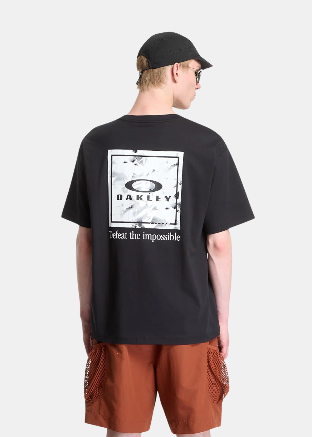 Vue de dos portée du t-shirt Oakley noir avec imprimé carré logo et sérigraphie "Defeat the impossible"