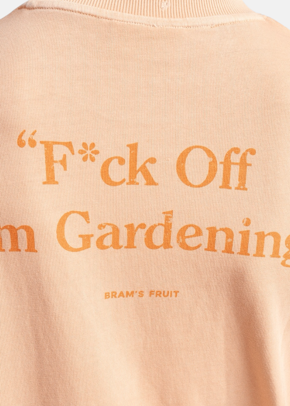 Zoom sur l'imprimé texturé au dos du t-shirt orange mentionnant F*ck Off I'm Gardening Bram's Fruit.