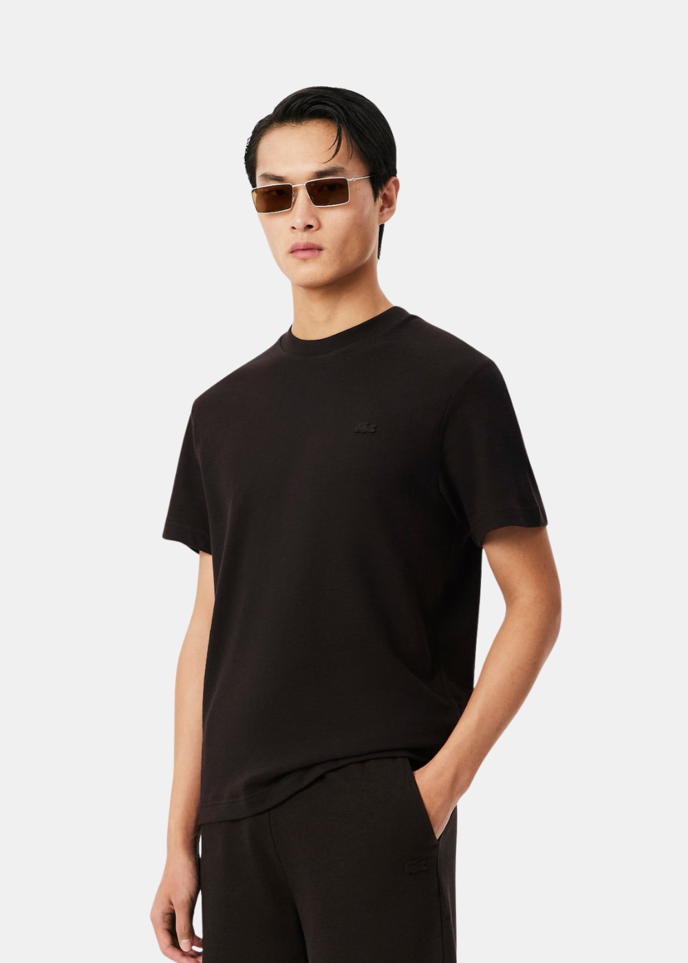 portrait d'un homme portant le t-shirt porto Lacoste col rond, vue de trois-quarts face.