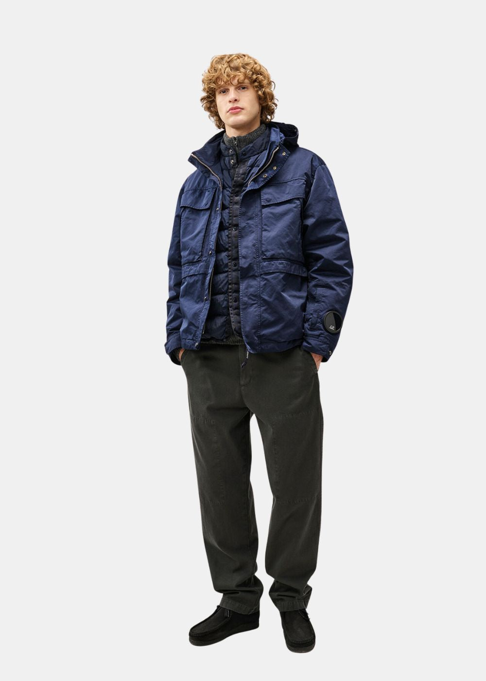 Mannequin homme portant la veste technique C.P. Company Mille bleue avec un pantalon sombre.