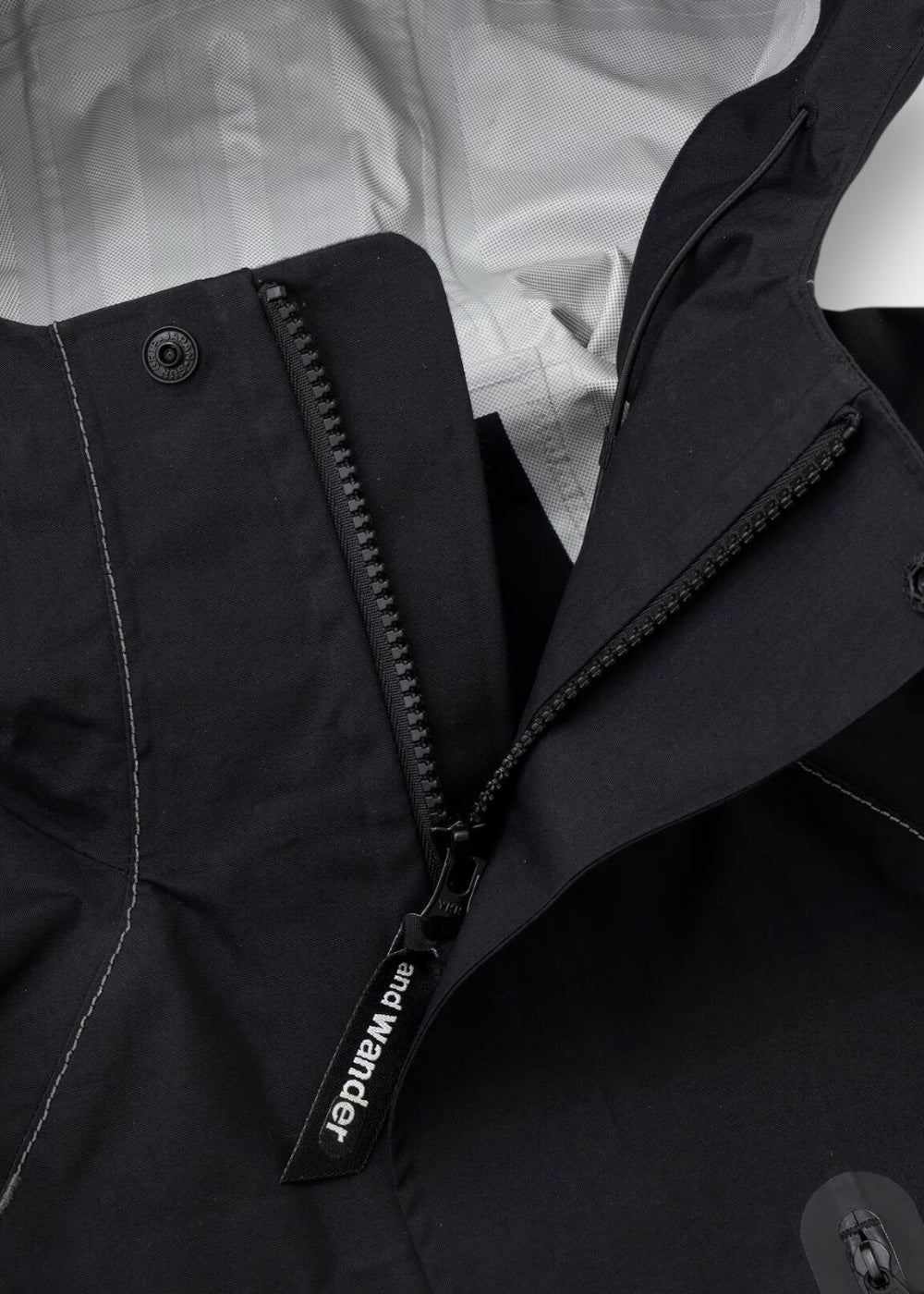 Zoom sur la fermeture éclair étanche et la protection de menton de la veste And Wander Hiker Rain.