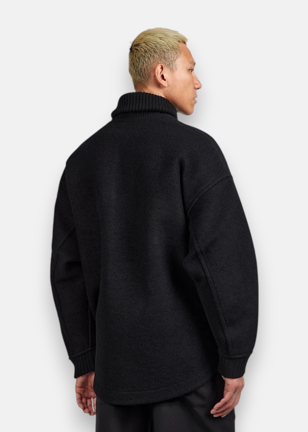 Vue de dos de la veste And Wander laine shaggy noire sur l'homme.