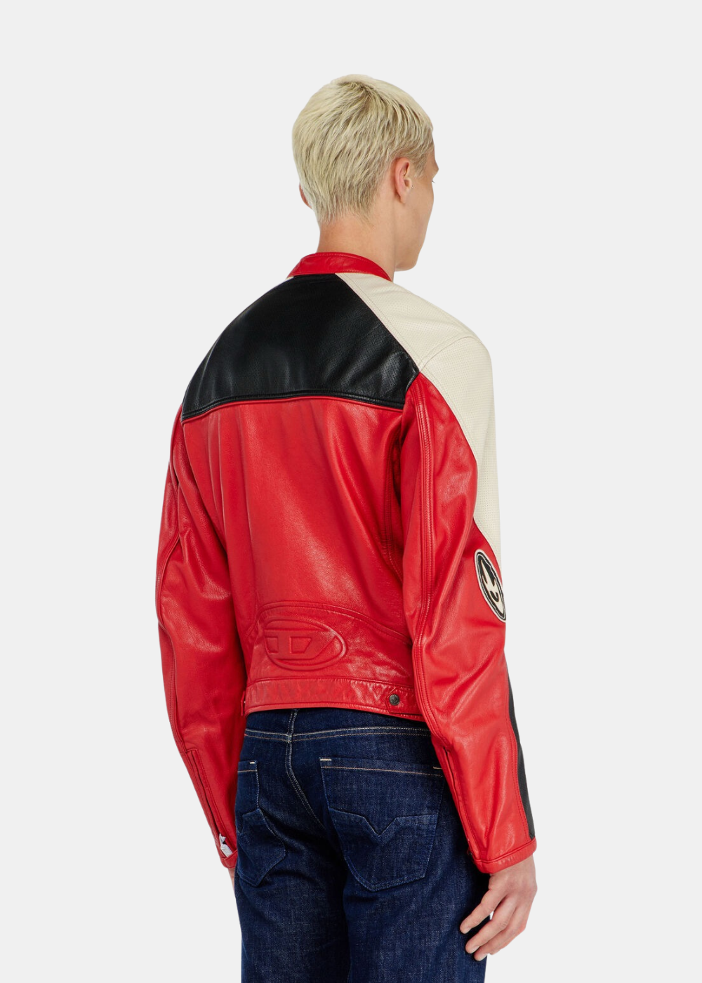 Vue de trois-quarts dos de la veste de motard Diesel en cuir rouge, montrant l'empiècement en cuir perforé noir sur le haut des épaules et le grand logo « D » emblématique discrètement embossé ton sur ton au bas du dos