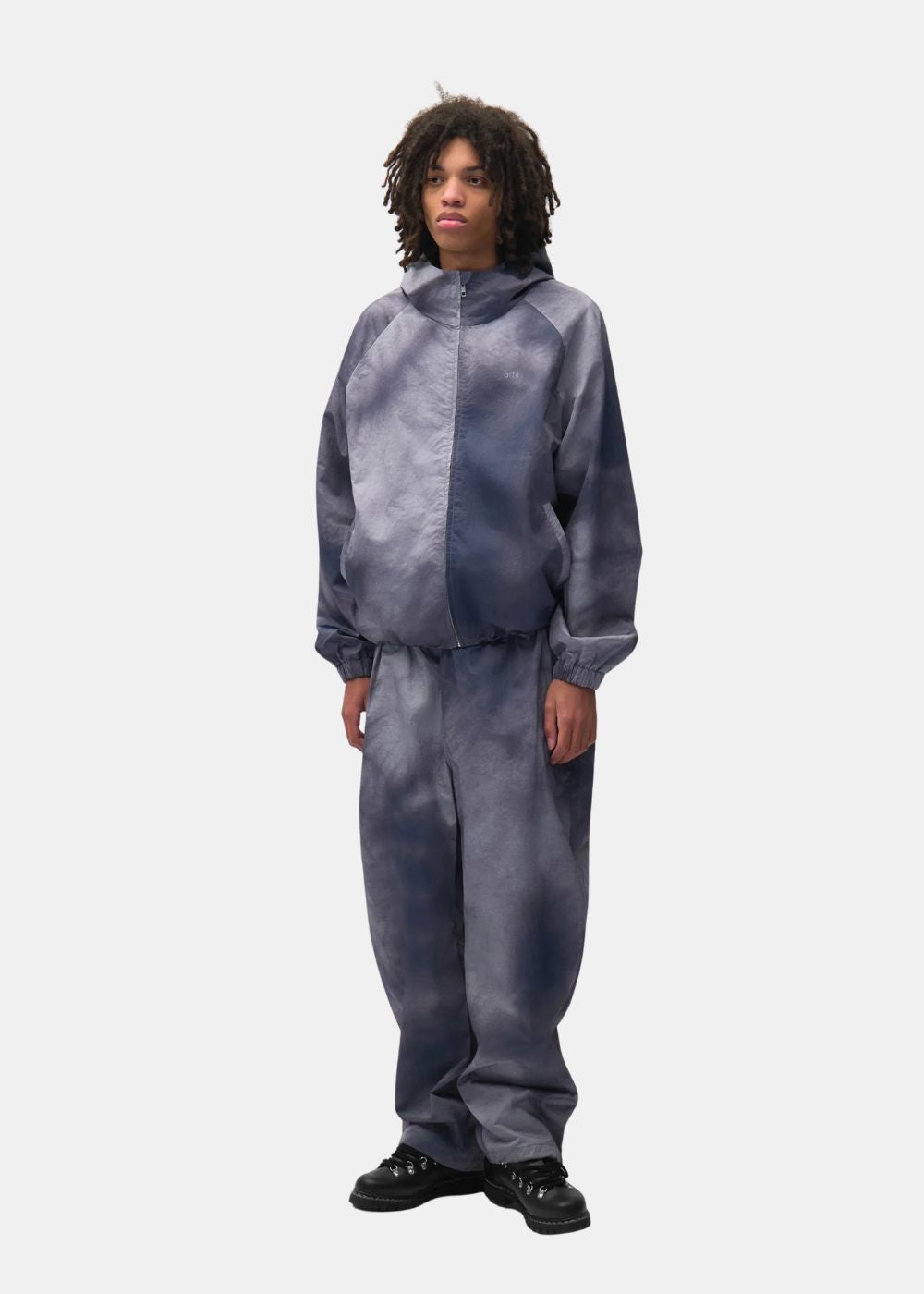 Look complet de face avec la veste à capuche Arte bleu gris zippée portée avec son pantalon assorti.