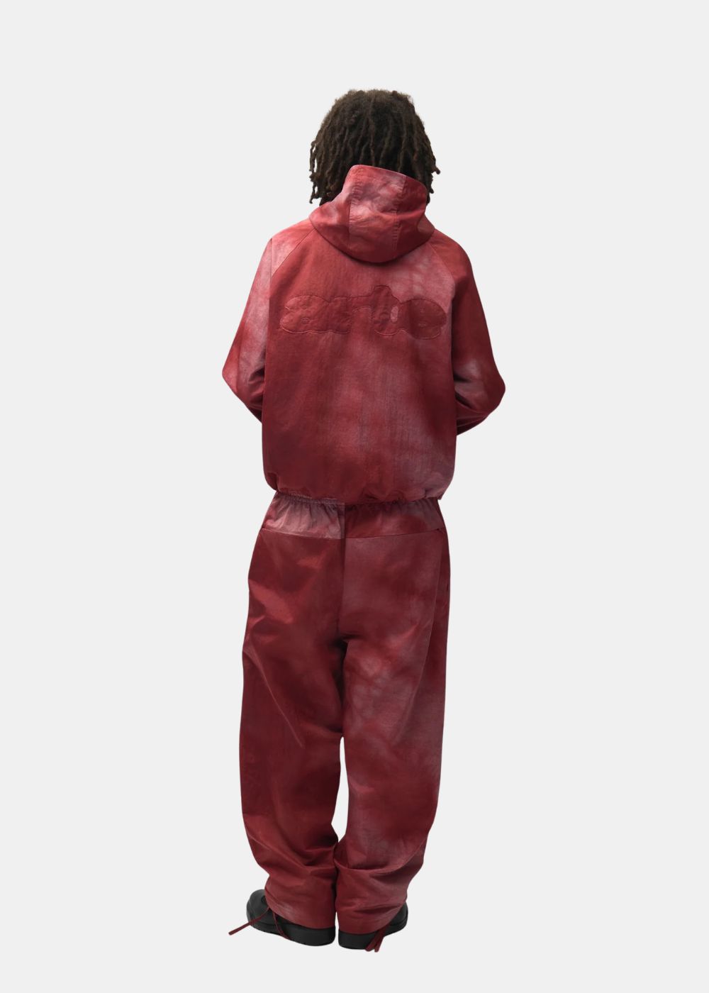 Vue d'ensemble de dos montrant l'ensemble de survêtement bordeaux tie-dye Arte porté avec capuche.