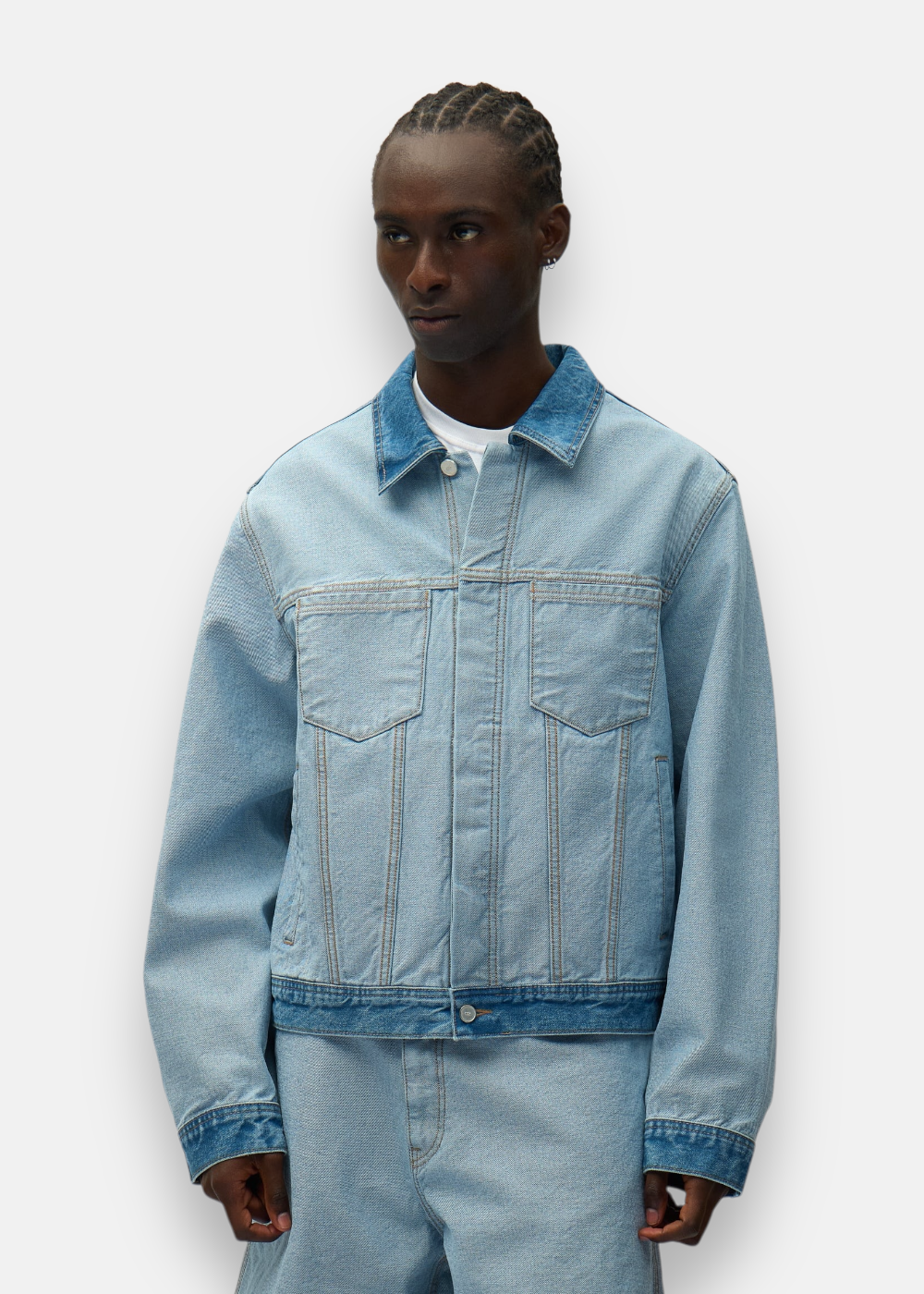 Veste en denim inversée bleu clair Arte Antwerp portée par un mannequin, style décontracté et déstructuré.