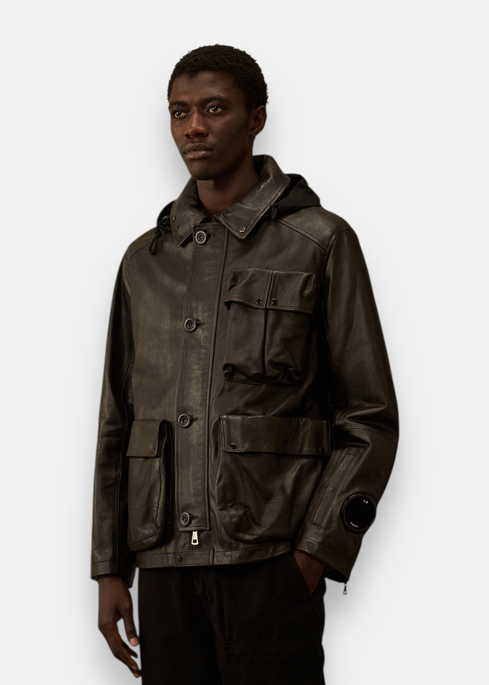 veste en cuir cp company porter par le mannequin avec sa lentille au poignet