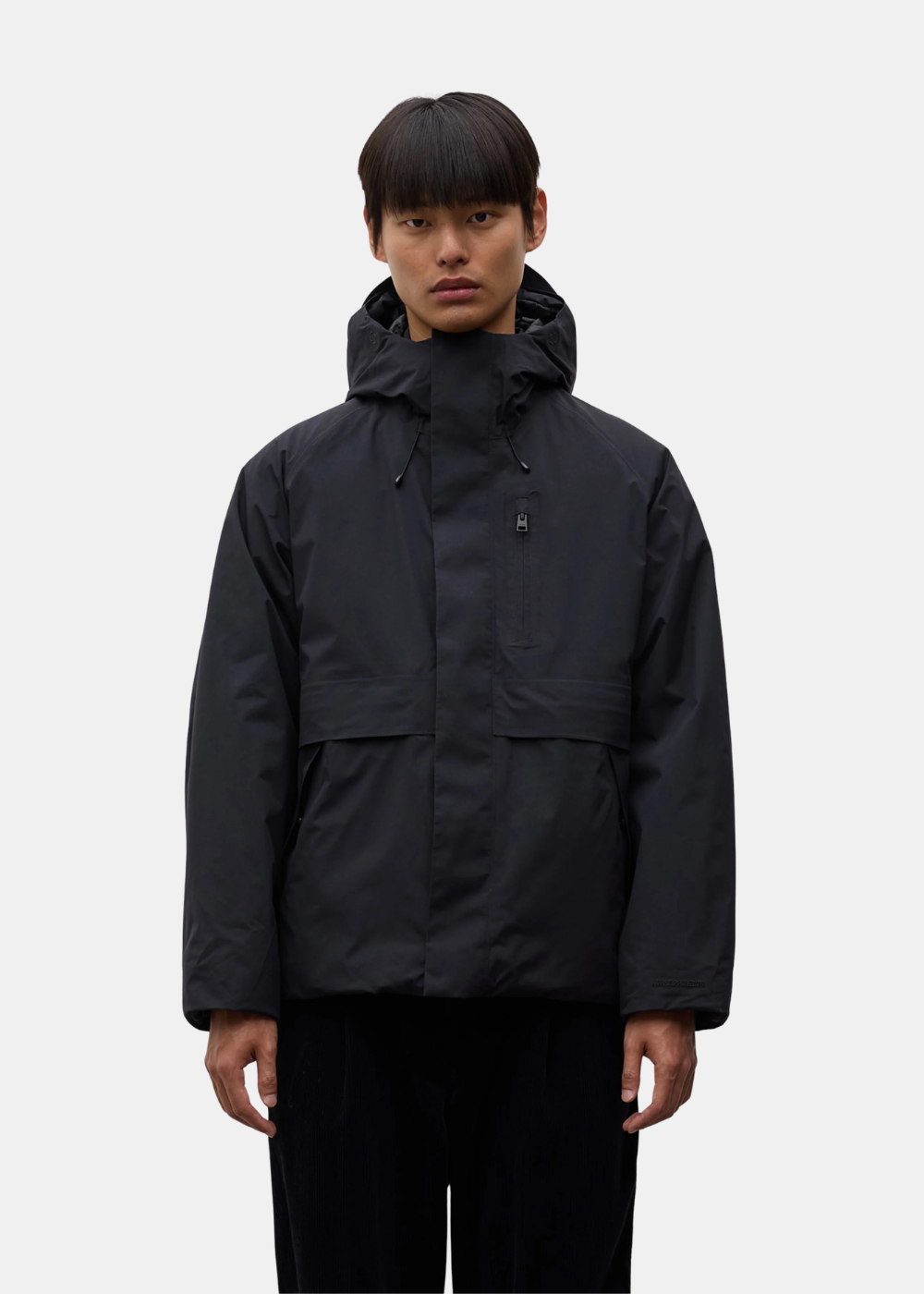 Veste imperméable Gore-Tex Norse Projects noire à capuche portée de face par un mannequin