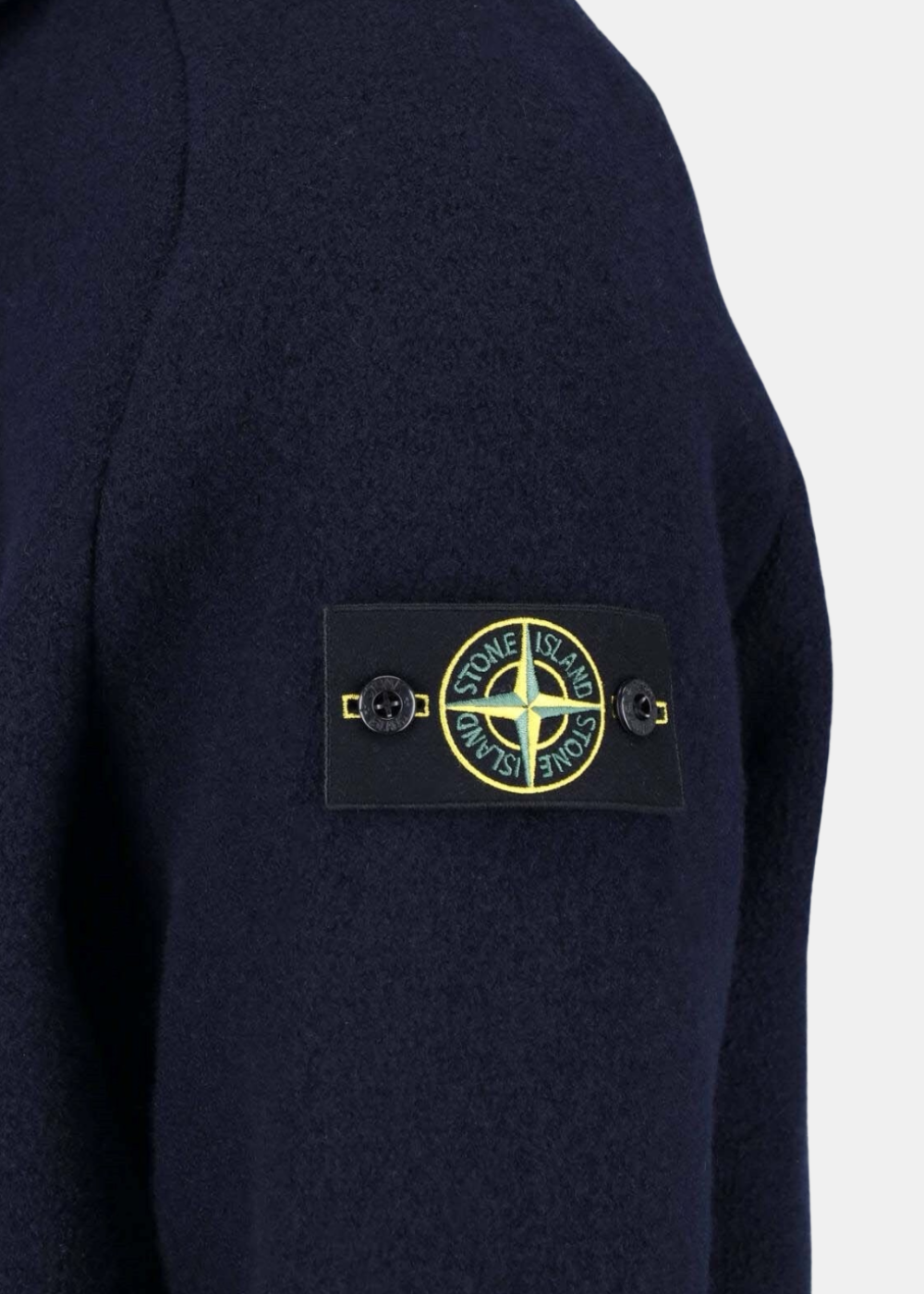 Gros plan sur le badge boussole Stone Island boutonnné sur la manche gauche de la veste Maglia Infeltrita marine