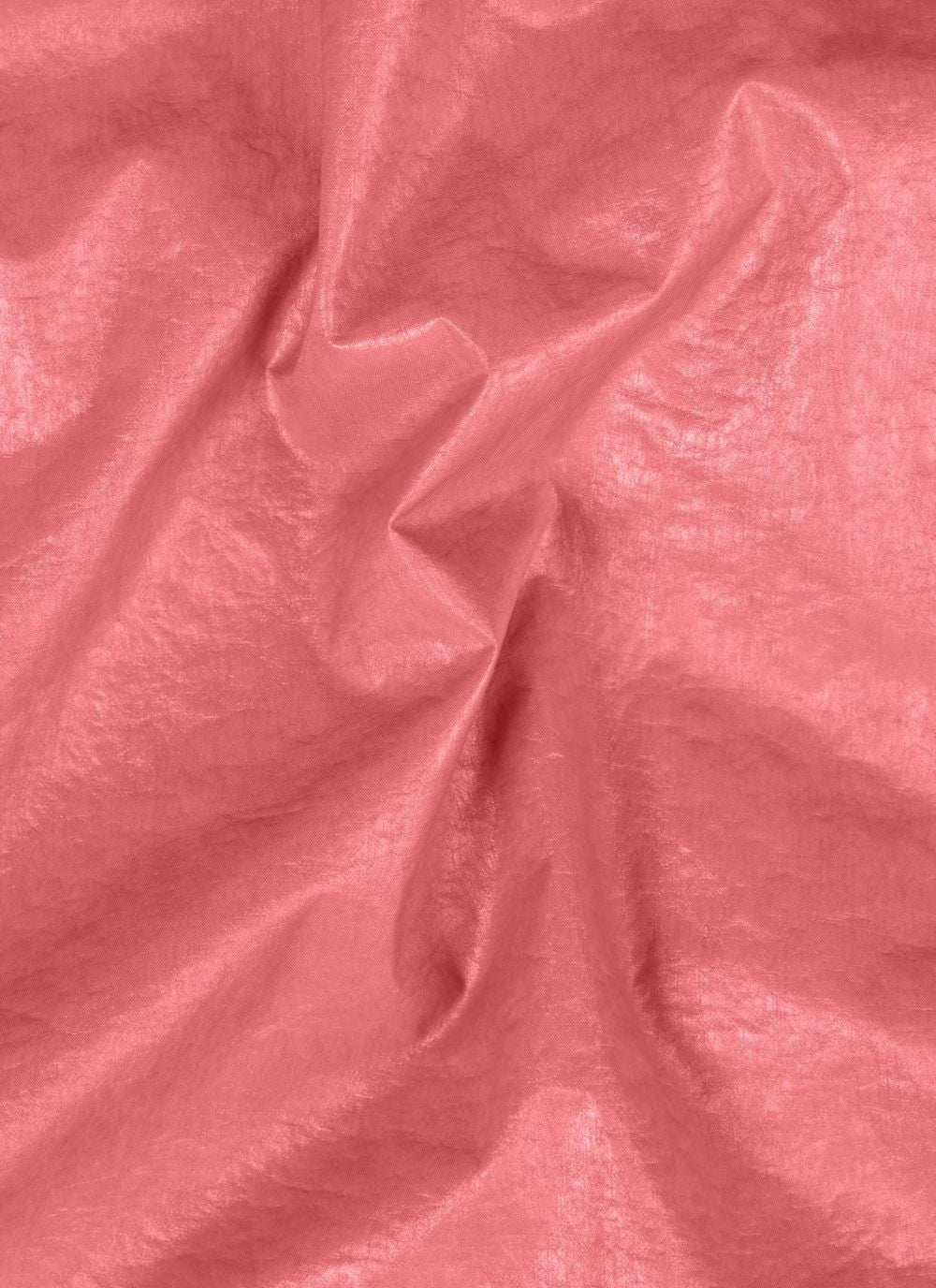 Gros plan sur le tissu technique rose légèrement froissé et brillant d'une veste légère Stone Island 3L TC.