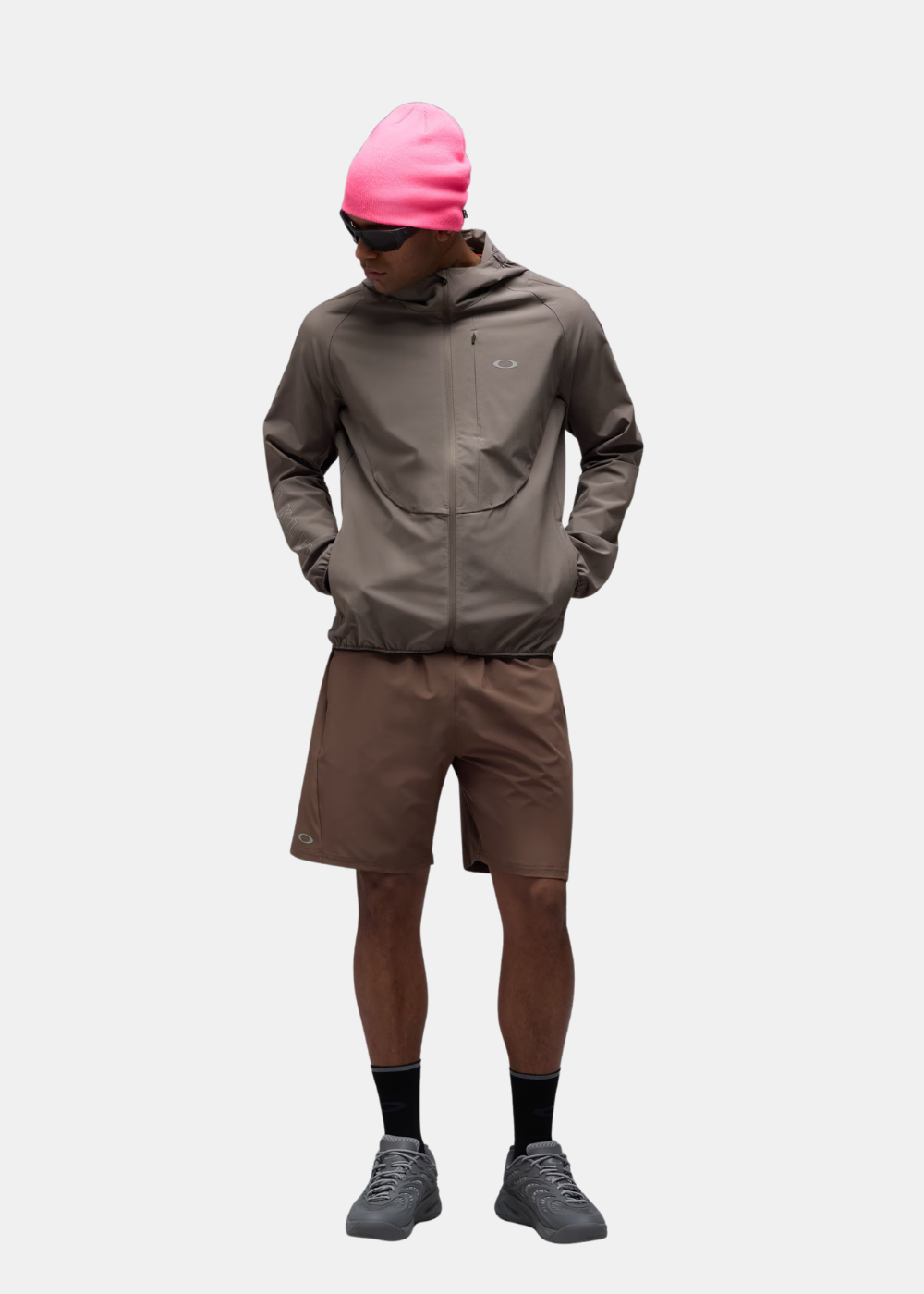 Mannequin portant la veste Oakley Edge Force taupe avec un bonnet rose et un short assorti