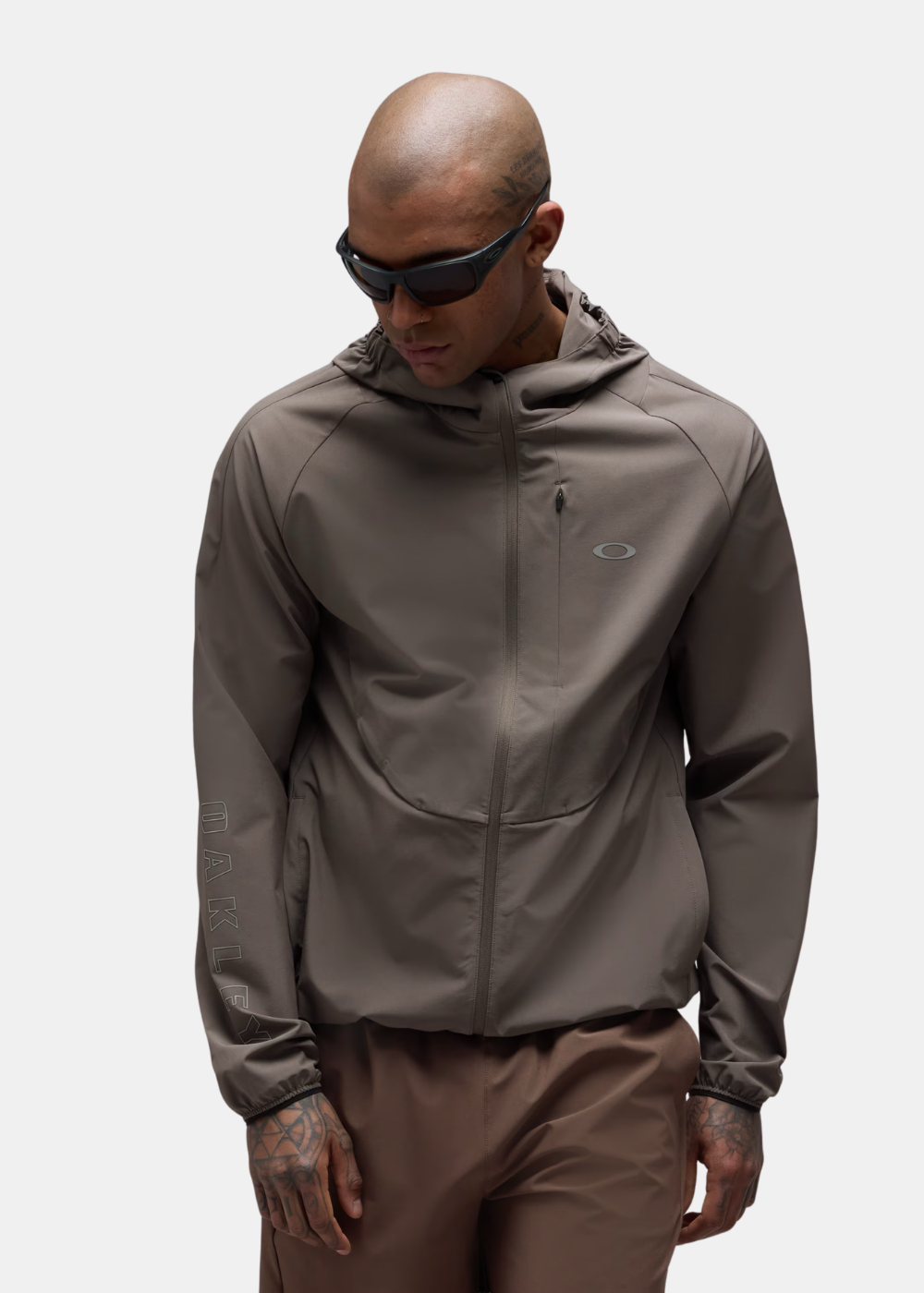Mannequin tatoué de face portant la veste à capuche Oakley Edge Force taupe avec lunettes de soleil