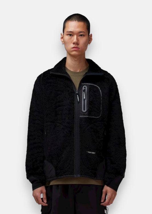 Homme portant la veste polaire High Loft And Wander noire, col montant.