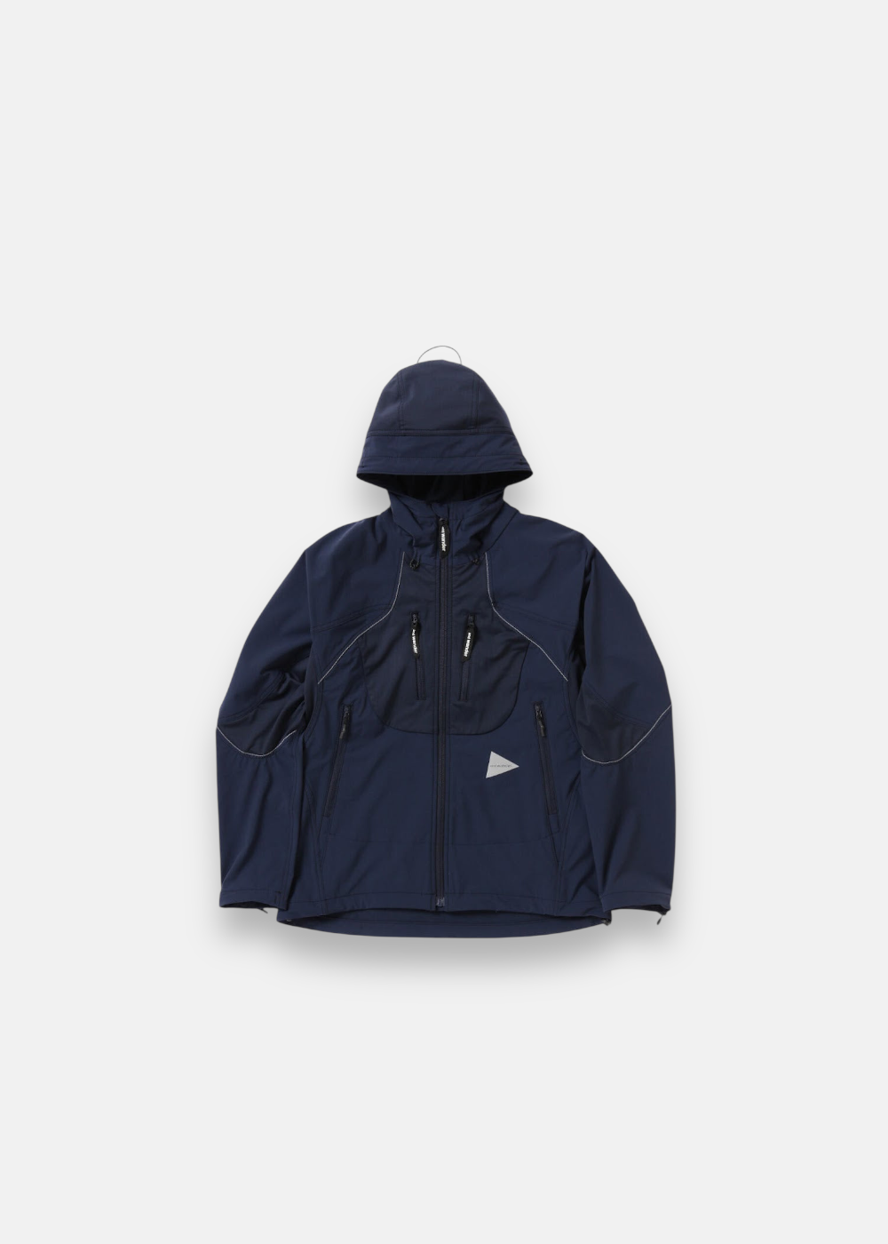 Veste de randonnée And Wander Stretch ZGRAV bleu marine, tissu technique, coupe-vent, avec coutures et logos réfléchissants.