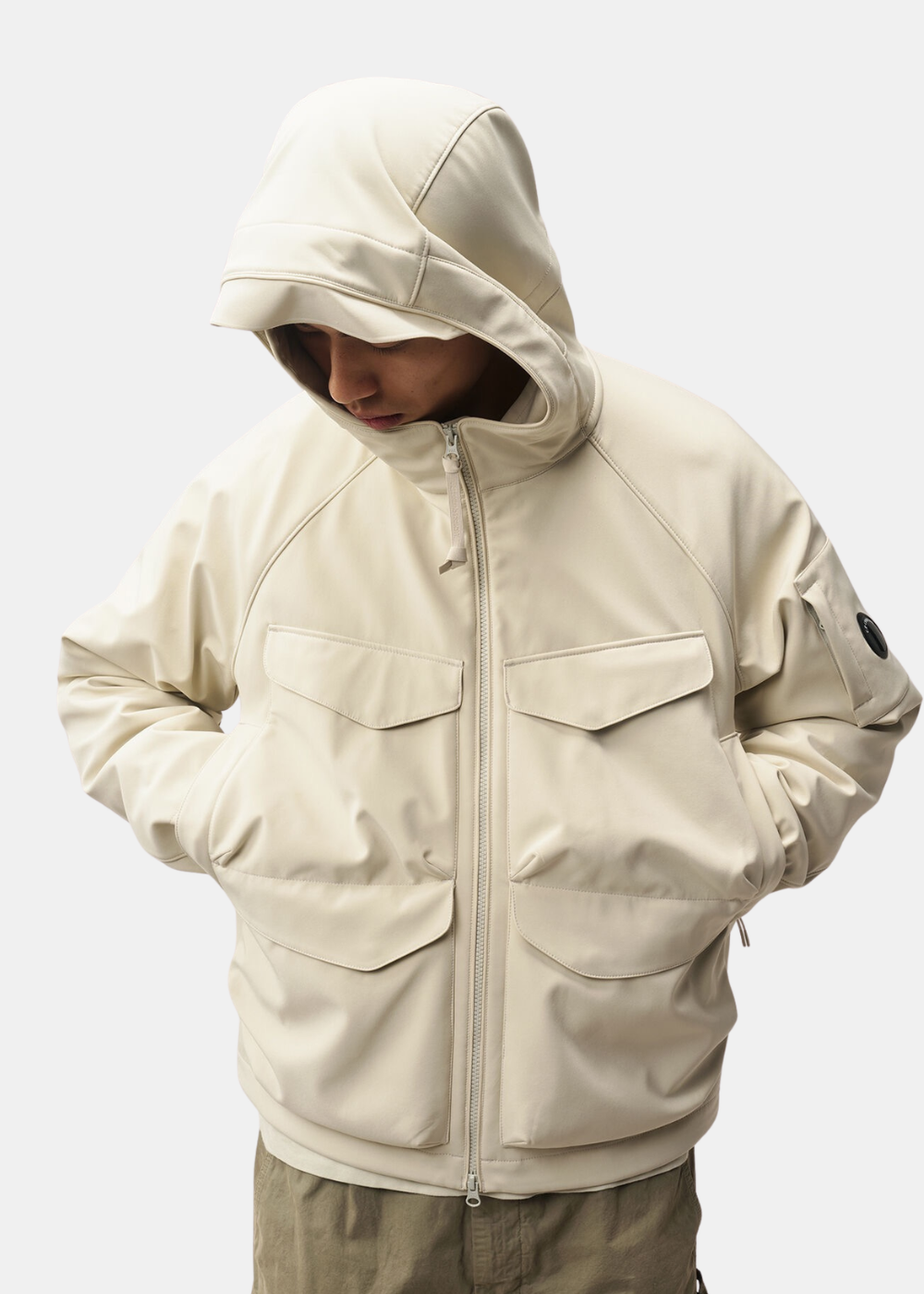 Gros plan sur le mannequin portant la capuche de la veste réversible beige C.P. Company