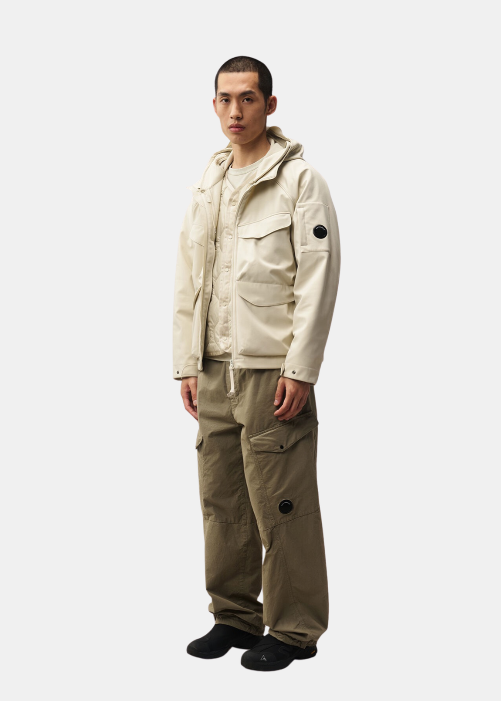 Mannequin homme portant la veste réversible beige C.P. Company avec un pantalon cargo olive