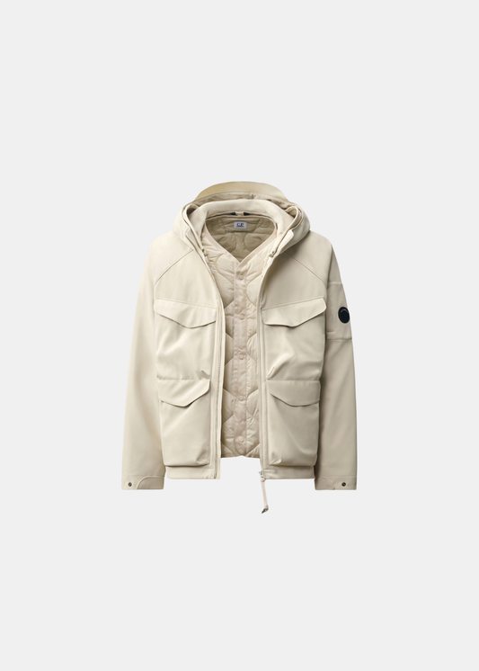 Packshot de la veste réversible beige C.P. Company ouverte dévoilant sa doublure matelassée