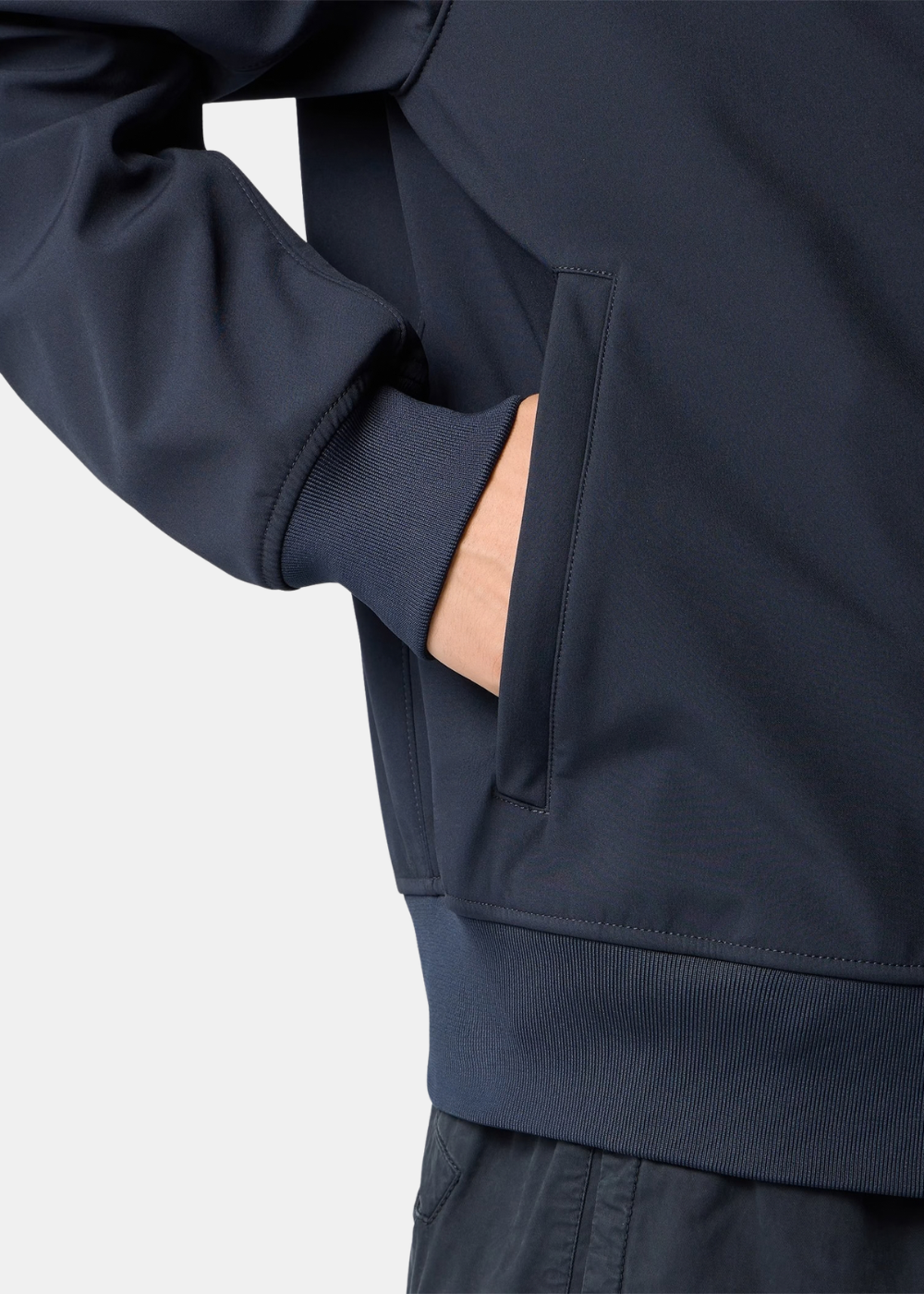 Primer plano del bolsillo lateral y puño elástico de la chaqueta Stone Island azul marino