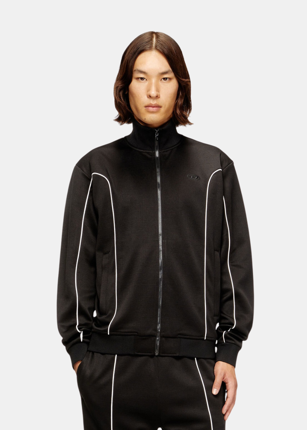 Mannequin homme portant de face la veste de survêtement noire Diesel avec liserés blancs et col montant.