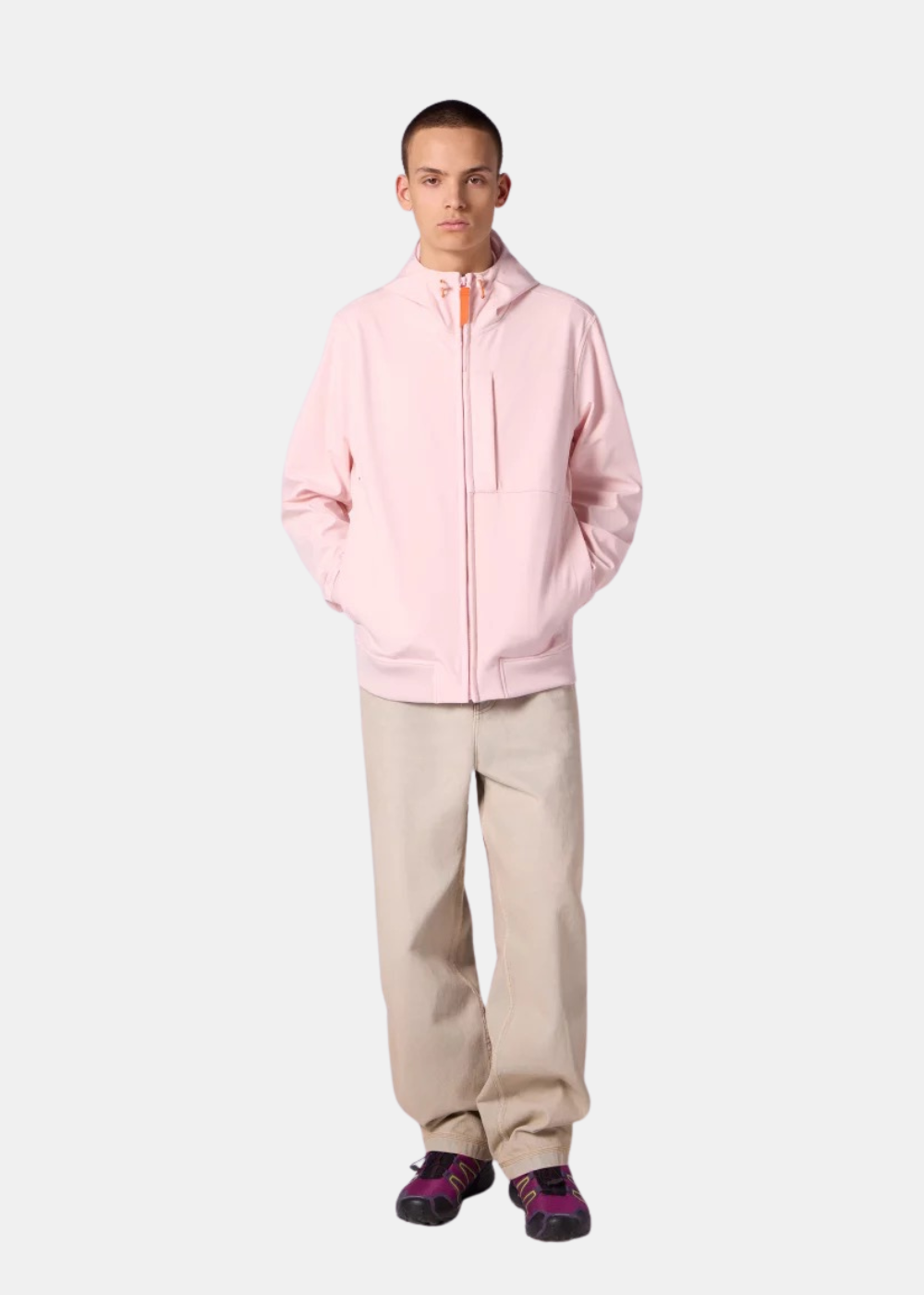 Homme portant la veste technique à capuche Gertrude Ronaldo rose pastel, fermeture zippée et poches frontales.