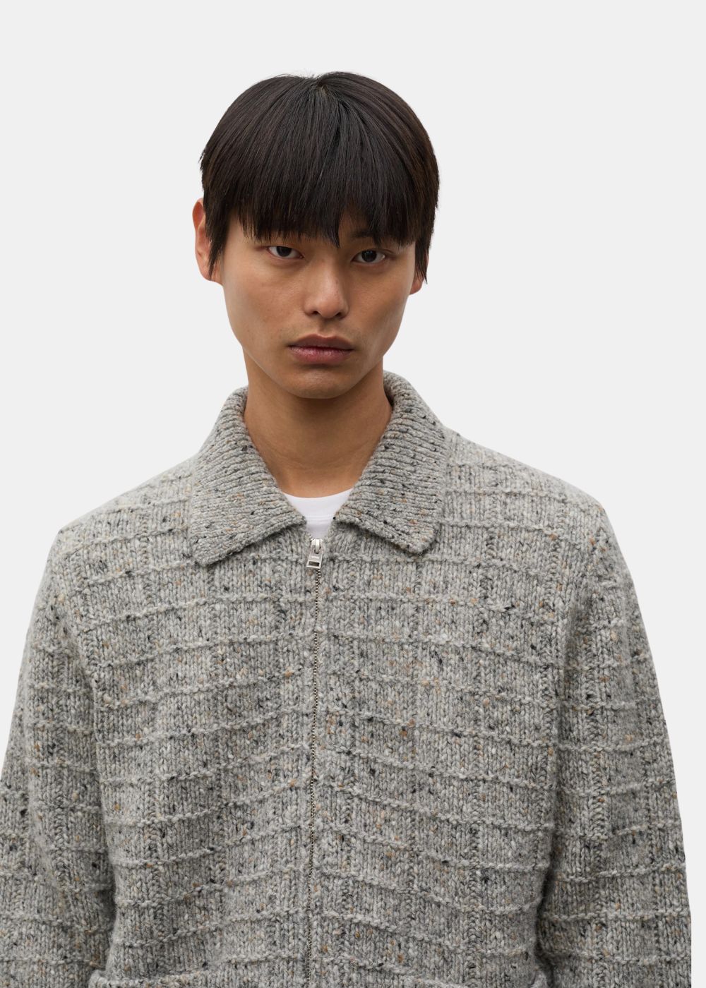 Gros plan sur le col chemise et la fermeture éclair métallique de la veste zippée en laine gris chiné Norse Projects