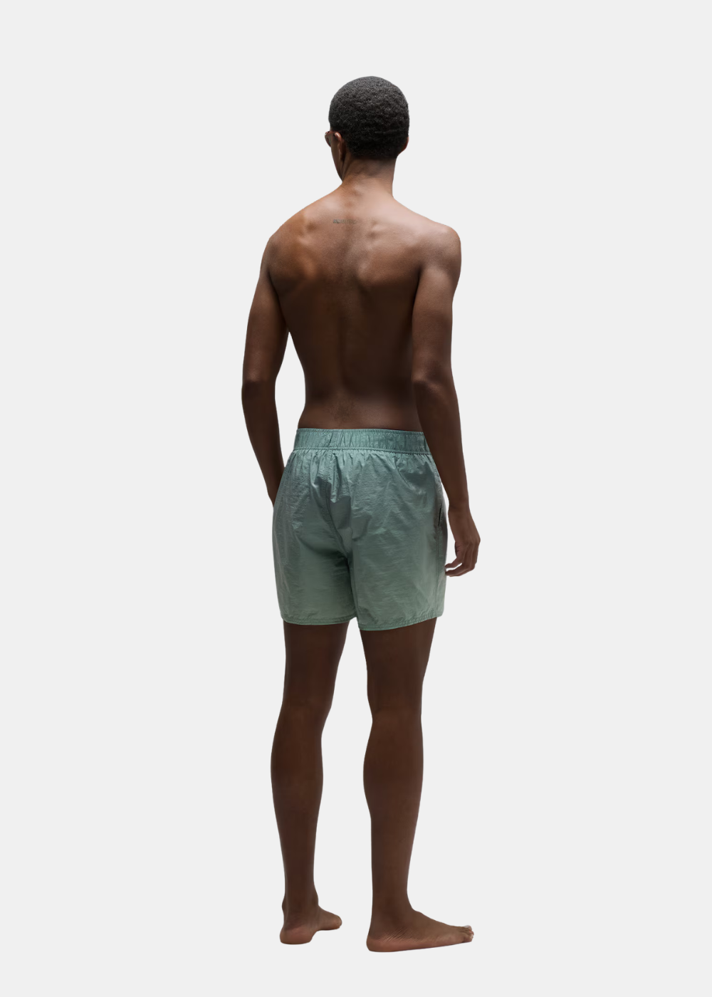 le mannnequin est de dos et porte le Short de bain oakley vert dégradé