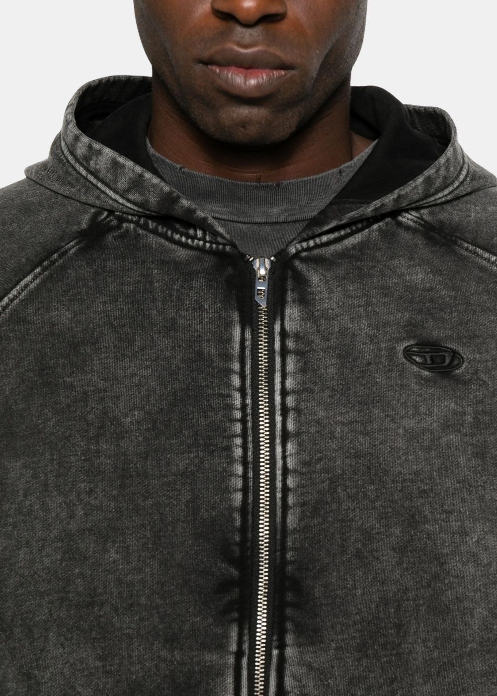 Gros plan sur le col et le logo ovale Diesel brodé, texture coton effet usé industriel gris foncé.