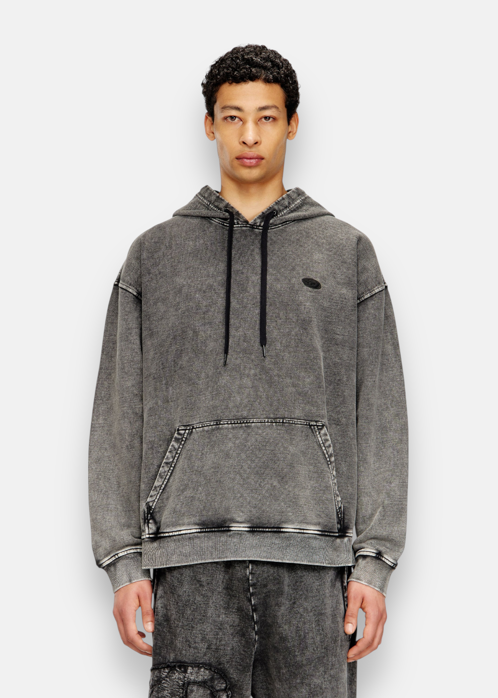 zoom sur le sweatshirt diesel s-boxt den hood sur un mannequin de face.. mis en avant du petit logo de devant et de la couleur gise